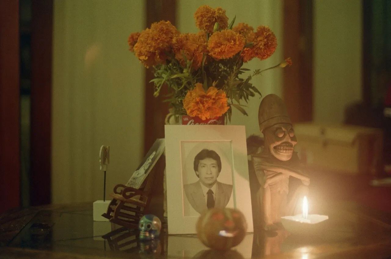 Altar de muertos con flores de cempasúchil, un retrato enmarcado y una vela encendida